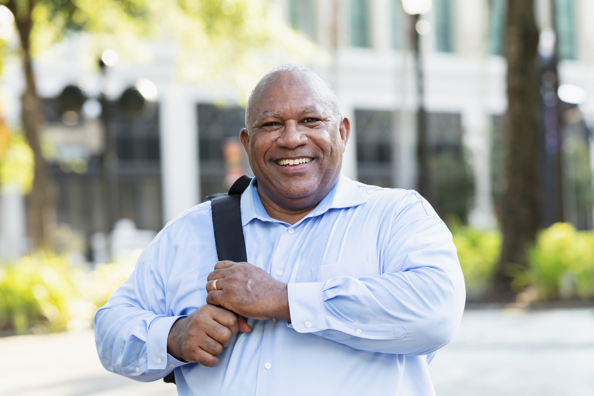 Senior Black businessman walking outdoors in the city