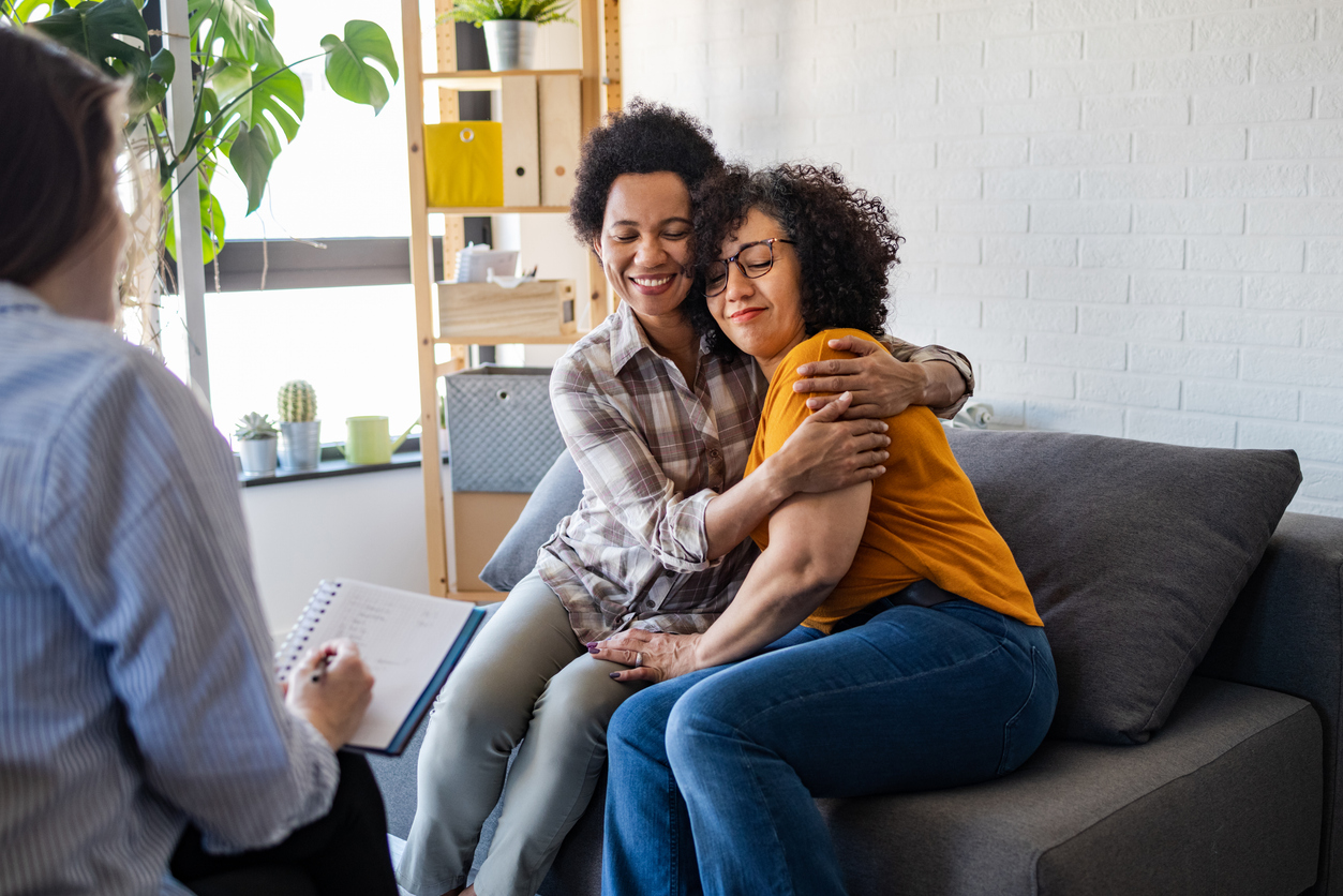 Lesbian couple embracing during relationship counseling. It seems that they solved a marriage problem.